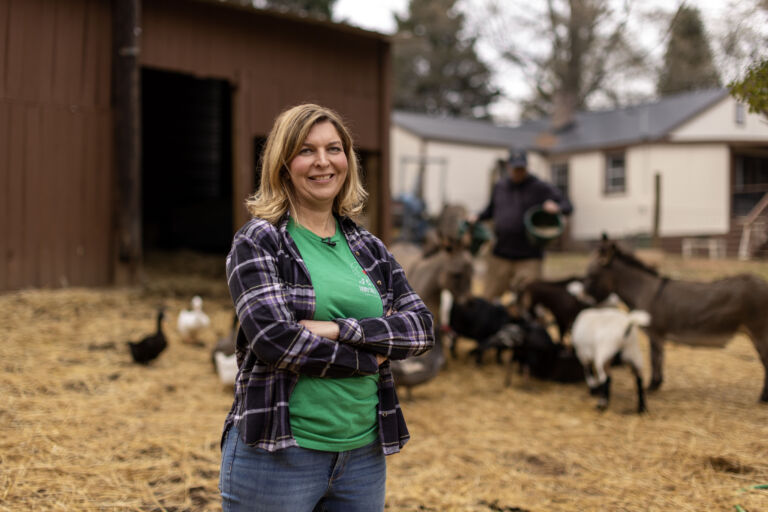 Kimberly Dunckel stands in front of animals at Fairytale Farm animal sanctuary